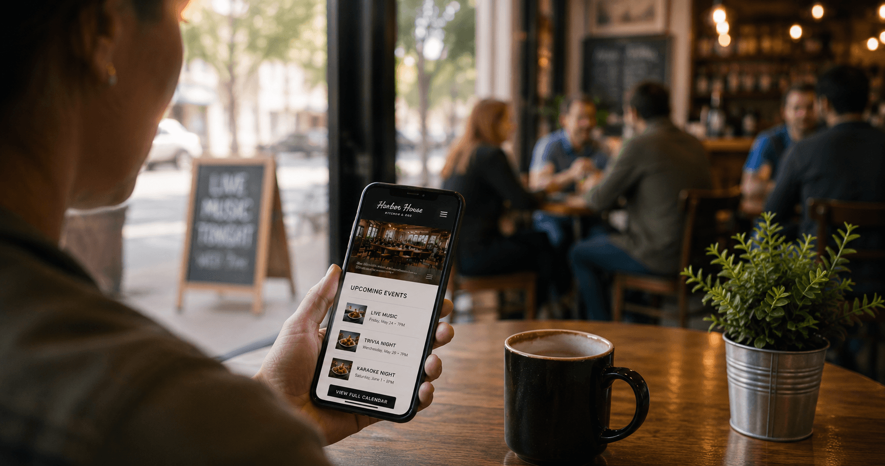 A customer checking a local business website on their phone inside a coffee shop.
